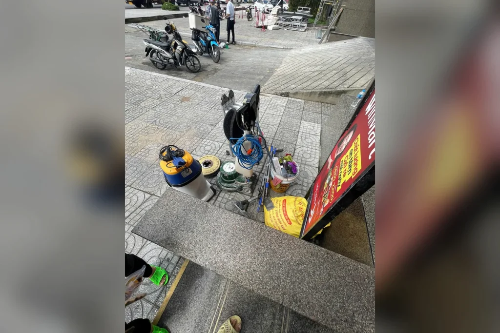 Nhân viên Minh Tín hút bụi thảm tại cửa hàng